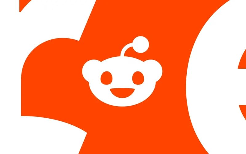 White logo of Reddit's smiling mascot Snoo on an orange and white background, with large letter fragments