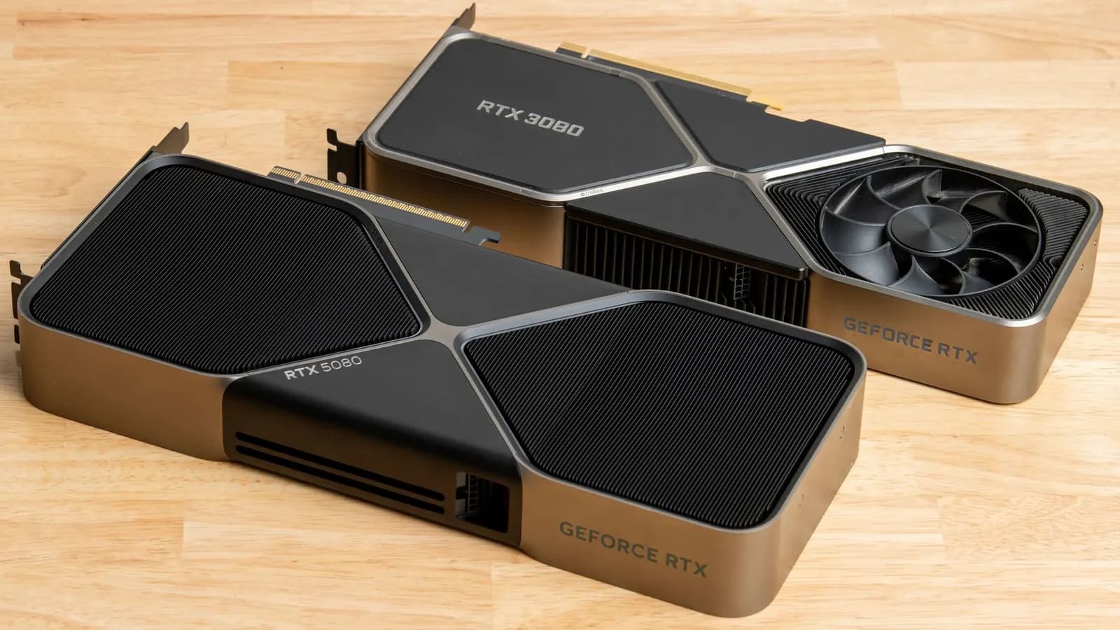 Ahşap bir yüzeyde yan yana duran iki NVIDIA GeForce RTX ekran kartı: RTX 5080 ve RTX 3080 Founders Edition