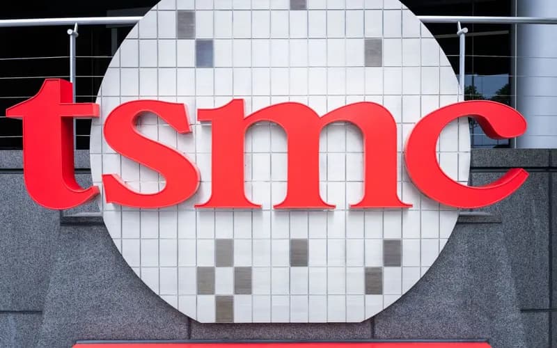 Bir binanın granit duvarında, yonga plakası şeklindeki beyaz fayanslı yuvarlak panonun üzerinde kırmızı TSMC logosu