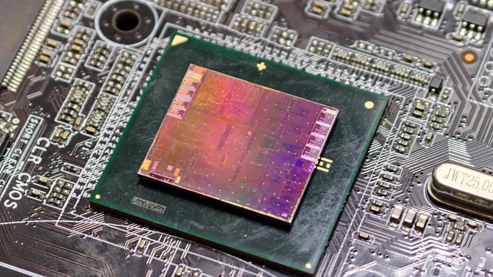 Close-up of a processor chip seated on a motherboard, with its exposed silicon die visible