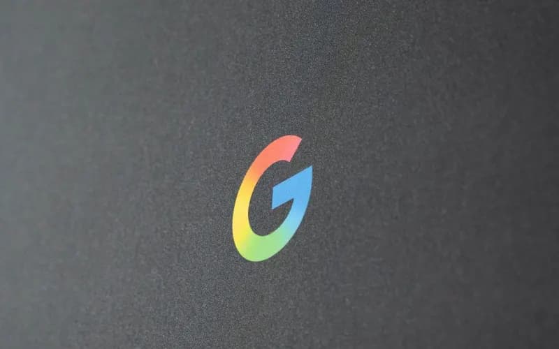 Google's colorful gradient "G" logo on a dark gray matte surface