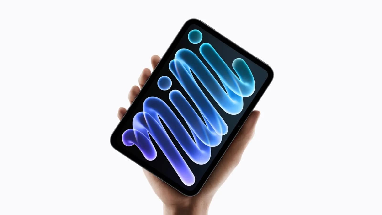 Hand holding an iPad mini with a glossy, flowing blue and purple abstract wallpaper on its screen.