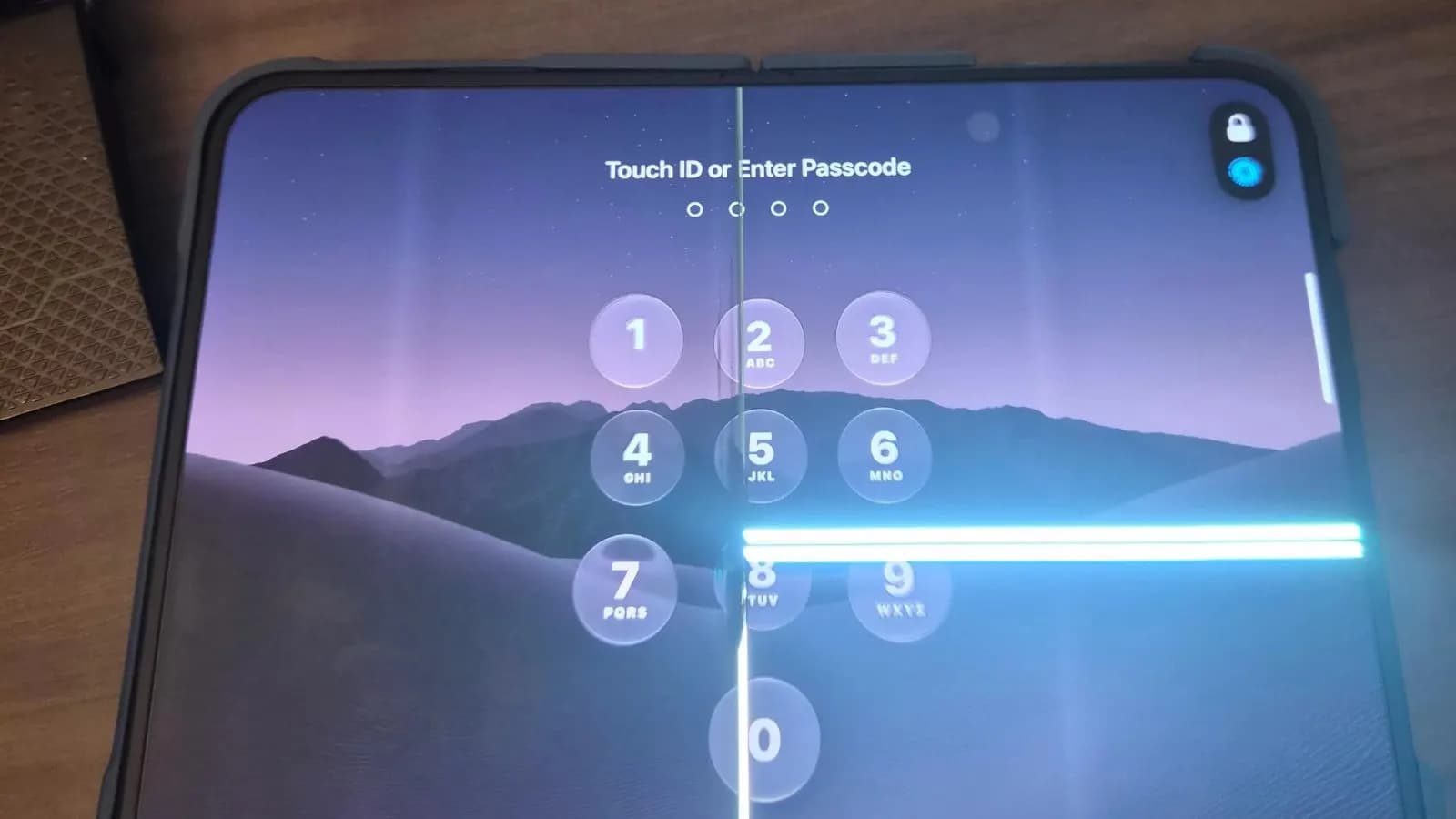 Katlanabilir bir tabletin kilit ekranında şifre girişi görünüyor; ekranda dikey çizgi ve parlak yatay çizgi arızaları var.