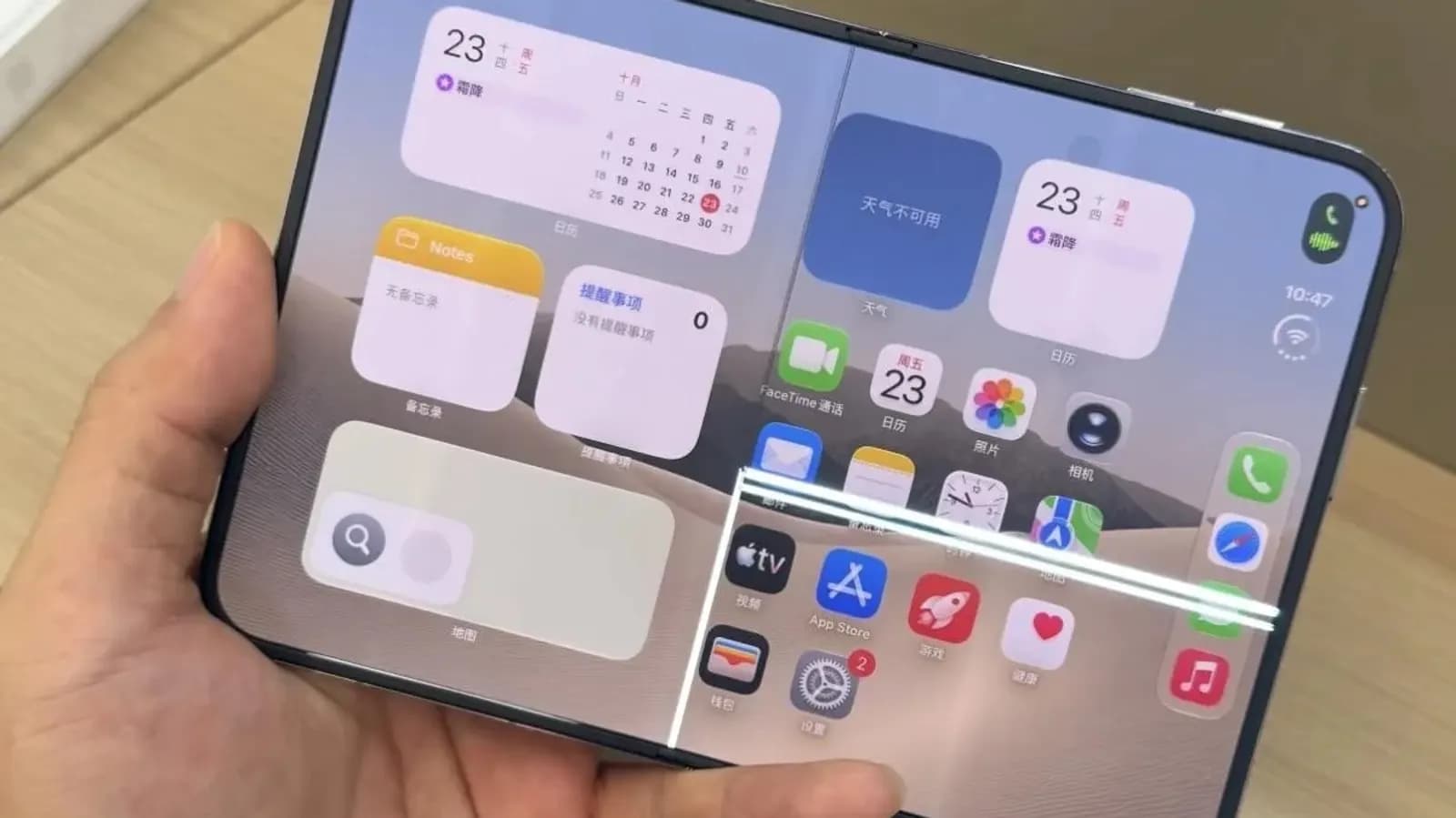 Hand holding a foldable phone showing an iOS-style home screen with calendar and notes widgets and app icons