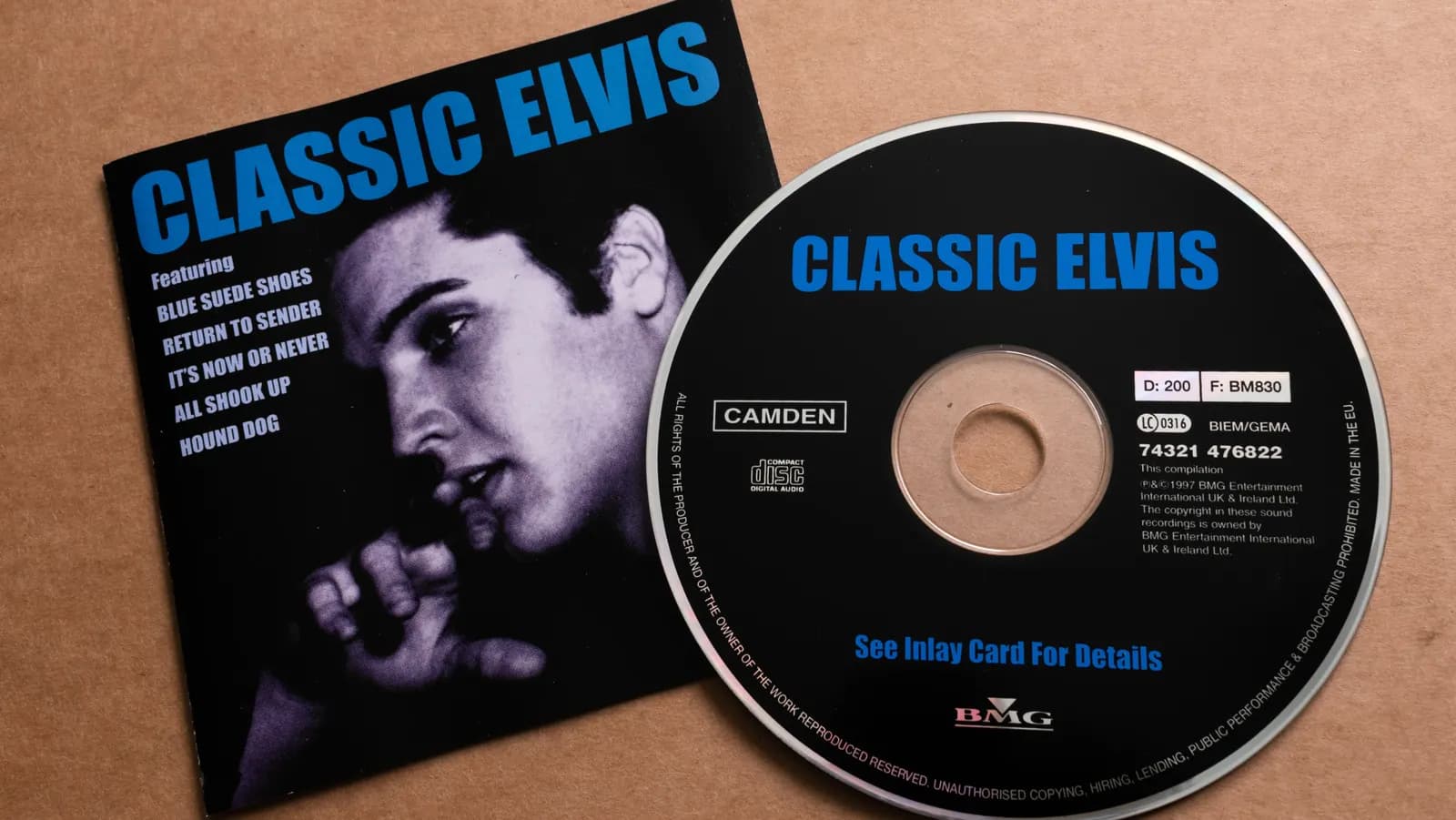Classic Elvis CD cover on a brown background beside a black and blue BMG-labeled compact disc.