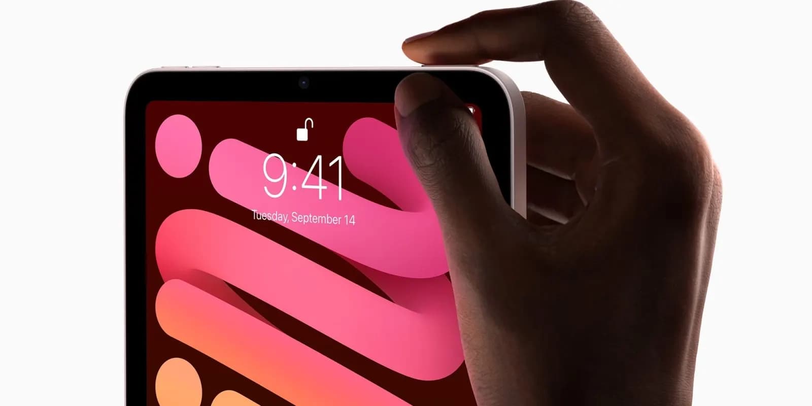 Bir elin parmağı, pembe renkli dalgalı duvar kâğıdına sahip tabletin üst kenarındaki düğmeye basıyor; ekranda saat 9:41 görünüyor.