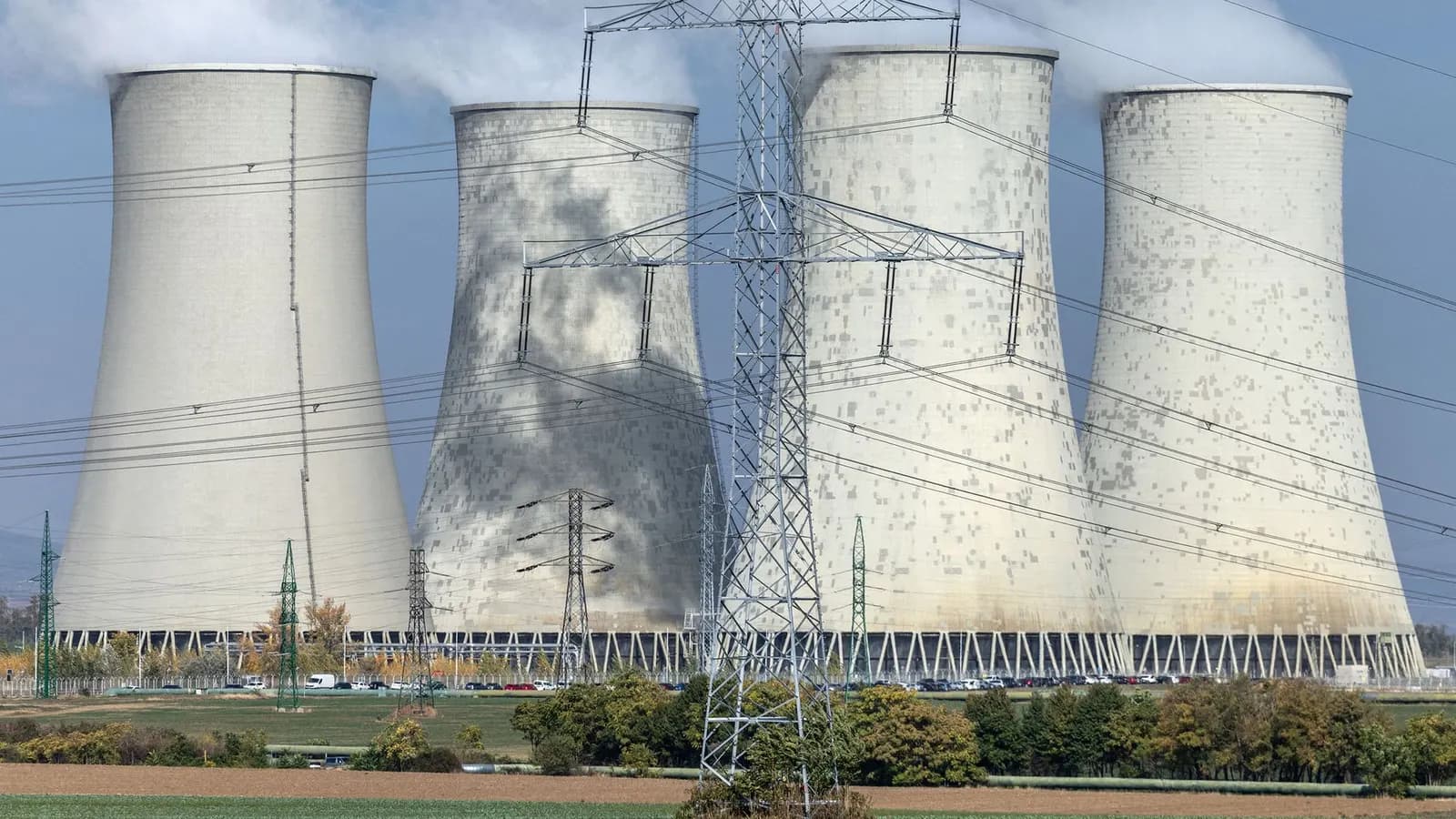 Dört büyük soğutma kulesi ve önlerinde yüksek gerilim hatları ile elektrik direkleri bulunan enerji santrali
