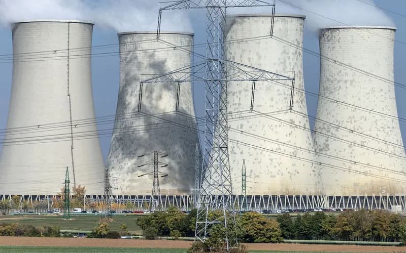 Dört büyük soğutma kulesi ve önlerinde yüksek gerilim hatları ile elektrik direkleri bulunan enerji santrali