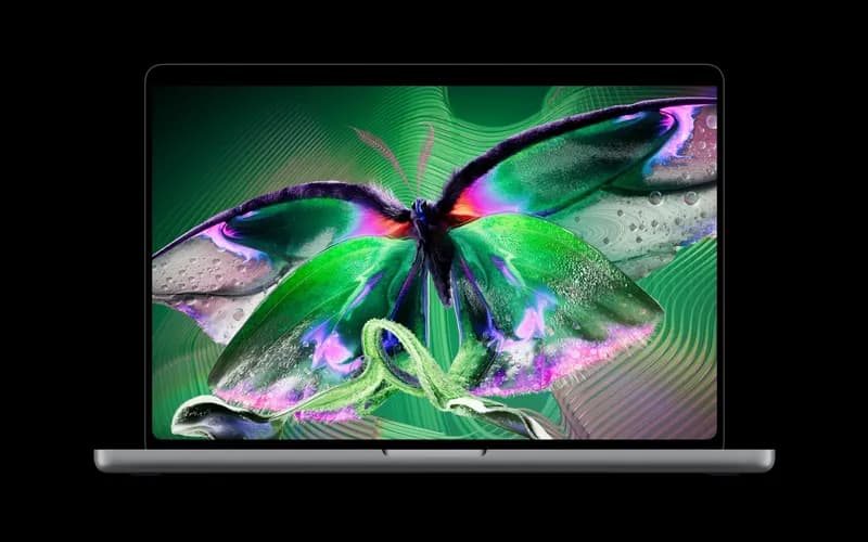 Open laptop against a black background, its screen showing a colorful butterfly illustration in green and purple tones.